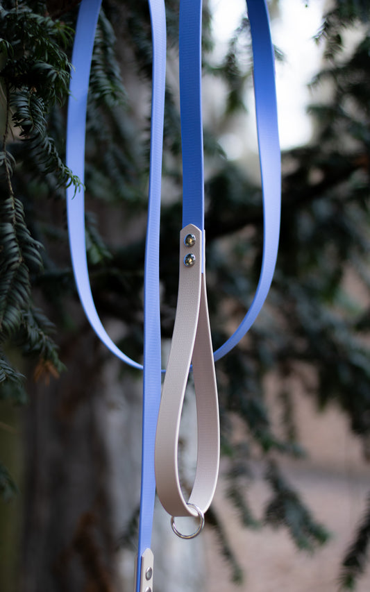 Na fotce je elegantní voděodolné biothanevodítko s ručkou v kombinaci modré a béžové. Toto lehce omyvatelné vodítko je děláno ručně na míru a skvěle se hodí na procházky se všemi plemeny psů.