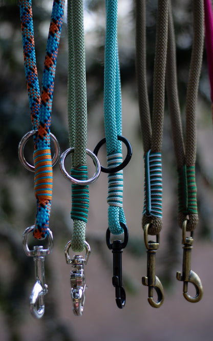 Na fotce vidíme krátké lanové vodítko - ručku neboli couračku, která se používá pokud chce člověk mít psa na krátko. Nechává se také na postroji pro rychlejší chycení psa na volno. Ručky jsou ručně pletené, mají zdobný oplet a mohou mít různé barvy, zde jsou konkrétně tyto barvy couraček (zleva): modro - oranžová (geometrické útvary), zelená, světle modrá, hnědá.