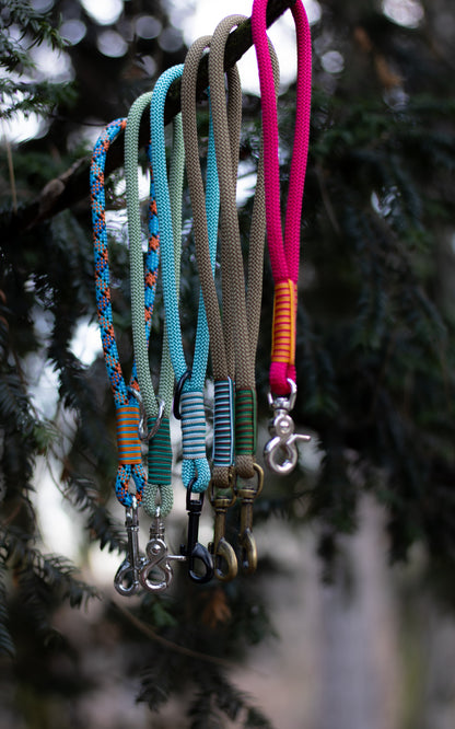 Na fotce vidíme krátké lanové vodítko - ručku neboli couračku, která se používá pokud chce člověk mít psa na krátko. Nechává se také na postroji pro rychlejší chycení psa na volno. Ručky jsou ručně pletené, mají zdobný oplet a mohou mít různé barvy, zde jsou konkrétně tyto barvy couraček (zleva): modro - oranžová (geometrické útvary), zelená, světle modrá, hnědá, červená.