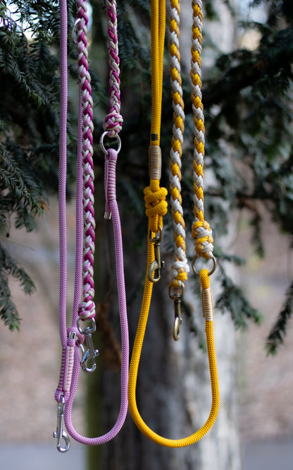 Růžové a žluté přepínací vodítko pletené z paracordu v kombinaci s lanem, vhodné na procházky se psem v přírodě i ve městě.